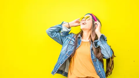  smiling-woman-looking-upright-standing-against-yellow-wall-1536619 